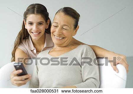 Preteen girl showing grandmother cell phone View Large Photo Image Stock Image - Preteen girl showing grandmother cell phone. Fotosearch