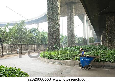 Public garden maintenance worker standing with cart under overpass View Large Photo Image Stock Image - Public garden maintenance worker standing with cart under overpass. Fotosearch