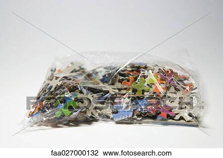 Stock Image - Puzzle pieces in plastic bag, close-up. Fotosearch