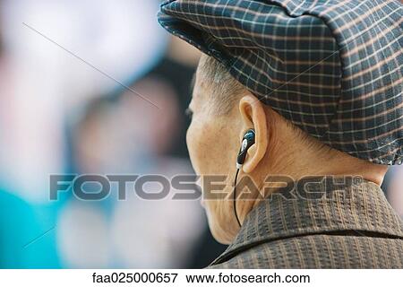 Senior man listening to earphones, rear view, head and shoulders View Large Photo Image Stock Photo - Senior man listening to earphones, rear view, head and shoulders. Fotosearch