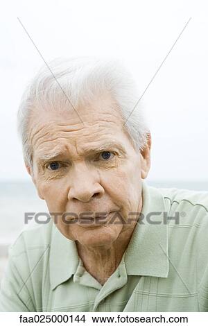 Senior man looking at camera, furrowing brow, portrait View Large Photo Image Picture - Senior man looking at camera, furrowing brow, portrait. Fotosearch