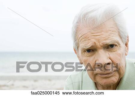 Senior man looking at camera, furrowing brow, close-up View Large Photo Image Stock Photography - Senior man looking at camera, furrowing brow, close-up. Fotosearch