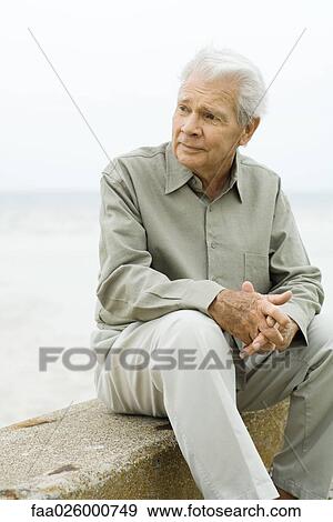 Senior man sitting near sea, looking away View Large Photo Image Stock Photo - Senior man sitting near sea, looking away. Fotosearch