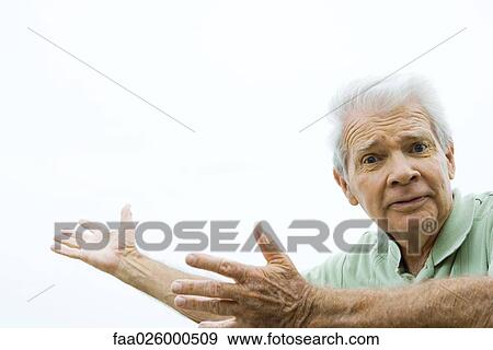 Senior man with arms out, furrowing brow, looking at camera View Large Photo Image Stock Photo - Senior man with arms out, furrowing brow, looking at camera. Fotosearch