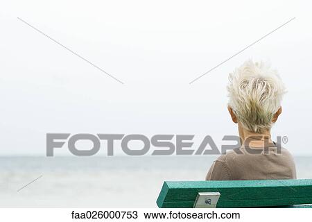 Senior woman sitting near sea, rear view View Large Photo Image Stock Image - Senior woman sitting near sea, rear view. Fotosearch