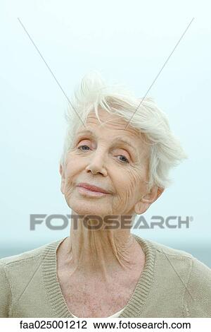 Senior woman smiling at camera, raising eyebrows, portrait View Large Photo Image Stock Image - Senior woman smiling at camera, raising eyebrows, portrait. Fotosearch