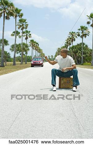 sitting, suitcase, car, road, hand raised, traveler View Large Photo Image Stock Photograph - sitting, suitcase, car, road, hand raised, traveler. Fotosearch