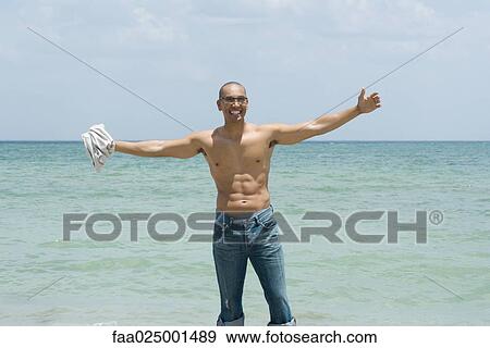 standing, barechested, arms outstretched, water's edge, toothy smile, mid adult men View Large Photo Image Stock Photo - standing, barechested, arms outstretched, water's edge, toothy smile, mid adult men. Fotosearch