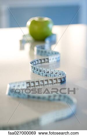 Stock Photo - Tape measure and green apple. Fotosearch