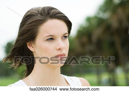 Teen girl looking away, hair blowing in wind, head and shoulders View Large Photo Image Picture - Teen girl looking away, hair blowing in wind, head and shoulders. Fotosearch
