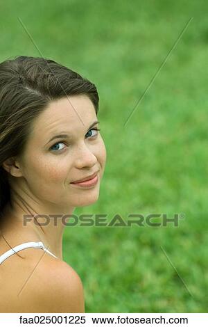 Teen girl looking over shoulder at camera, cropped, head and shoulders, grass in background View Large Photo Image Stock Photography - Teen girl looking over shoulder at camera, cropped, head and shoulders, grass in background. Fotosearch