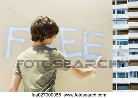 Teenage boy spray painting the word "free" on wall, rear view View Large Photo Image Stock Photography - Teenage boy spray painting the word "free" on wall, rear view. Fotosearch
