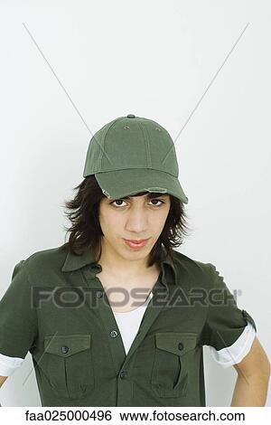 Teenage boy wearing baseball cap, looking at camera View Large Photo Image Stock Photograph - Teenage boy wearing baseball cap, looking at camera. Fotosearch