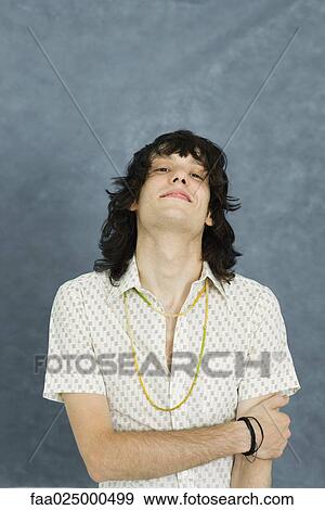 Teenage boy with arms folded, head back, looking at camera View Large Photo Image Stock Photo - Teenage boy with arms folded, head back, looking at camera. Fotosearch