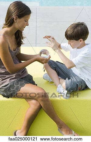 Teenage girl and younger brother sitting, looking at crystal ball together View Large Photo Image Stock Image - Teenage girl and younger brother sitting, looking at crystal ball together. Fotosearch