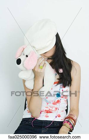 Teenage girl hiding face with stuffed toy, laughing View Large Photo Image Stock Photograph - Teenage girl hiding face with stuffed toy, laughing. Fotosearch