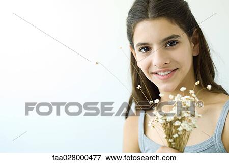 Teenage girl holding flower bouquet, smiling at camera, portrait View Large Photo Image Stock Photo - Teenage girl holding flower bouquet, smiling at camera, portrait. Fotosearch