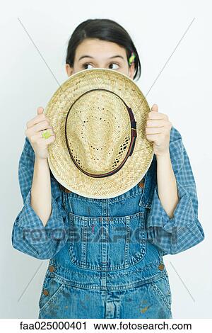 Teenage girl holding straw hat in front of face, looking away View Large Photo Image Stock Image - Teenage girl holding straw hat in front of face, looking away. Fotosearch