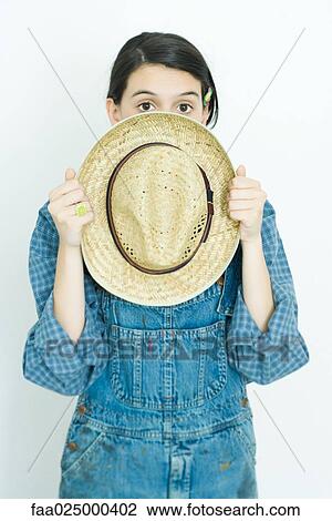 Teenage girl holding straw hat in front of face, looking at camera View Large Photo Image Stock Image - Teenage girl holding straw hat in front of face, looking at camera. Fotosearch