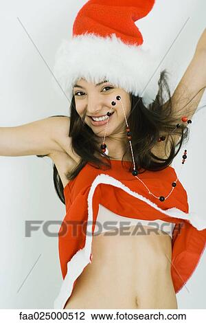 Teenage girl in Santa hat jumping, smiling at camera, midriff exposed View Large Photo Image Stock Image - Teenage girl in Santa hat jumping, smiling at camera, midriff exposed. Fotosearch