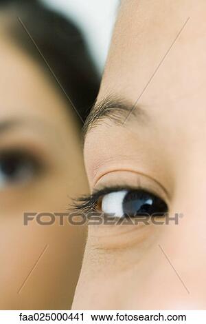 Stock Image - Teenage girl looking at camera, cropped view of eye. Fotosearch