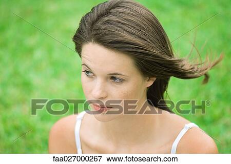 Teenage girl looking away, hair tousled by wind, high angle view View Large Photo Image Stock Photo - Teenage girl looking away, hair tousled by wind, high angle view. Fotosearch