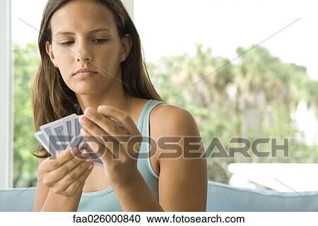 Teenage girl looking down at cards in hand, close-up View Large Photo Image Stock Image - Teenage girl looking down at cards in hand, close-up. Fotosearch