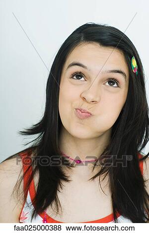Teenage girl looking up with puffed cheeks, portrait View Large Photo Image Stock Photo - Teenage girl looking up with puffed cheeks, portrait. Fotosearch