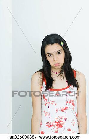 Stock Photo - Teenage girl pouting, looking at camera, portrait. Fotosearch