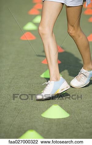 Teenage girl running through plastic cones, low angle view, cropped View Large Photo Image Stock Image - Teenage girl running through plastic cones, low angle view, cropped. Fotosearch