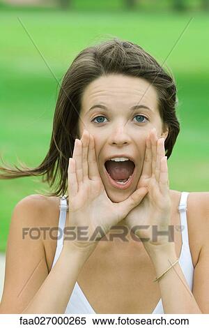 Teenage girl shouting, hands raised to mouth, looking at camera View Large Photo Image Stock Photography - Teenage girl shouting, hands raised to mouth, looking at camera. Fotosearch