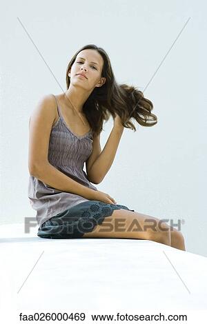 Teenage girl sitting, hand in hair, looking at camera View Large Photo Image Stock Photo - Teenage girl sitting, hand in hair, looking at camera. Fotosearch