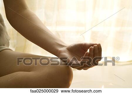 Teenage girl sitting in lotus position, cropped view of hand View Large Photo Image Stock Photo - Teenage girl sitting in lotus position, cropped view of hand. Fotosearch