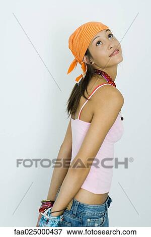 Teenage girl standing with arms behind back, looking up, side view View Large Photo Image Stock Photo - Teenage girl standing with arms behind back, looking up, side view. Fotosearch