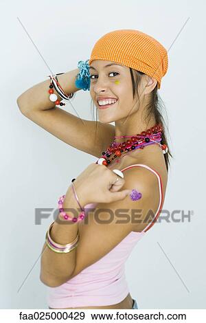 Teenage girl wearing bandana, smiling over shoulder at camera, side view View Large Photo Image Stock Photo - Teenage girl wearing bandana, smiling over shoulder at camera, side view. Fotosearch