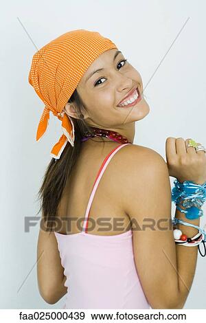 Teenage girl wearing bandana, smiling over shoulder at camera View Large Photo Image Stock Photo - Teenage girl wearing bandana, smiling over shoulder at camera. Fotosearch