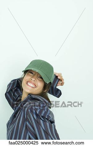 Teenage girl wearing button down shirt and cap, smiling at camera View Large Photo Image Stock Photography - Teenage girl wearing button down shirt and cap, smiling at camera. Fotosearch