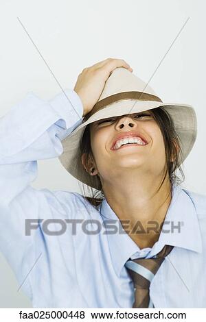 Teenage girl wearing tie, holding hat on head and smiling at camera View Large Photo Image Stock Photo - Teenage girl wearing tie, holding hat on head and smiling at camera. Fotosearch