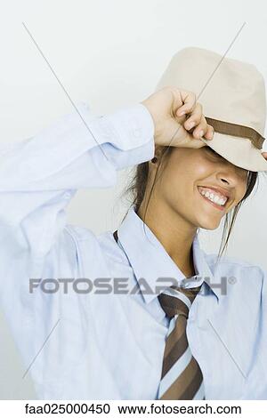 Teenage girl wearing tie, pulling hat over eyes, smiling at camera View Large Photo Image Stock Image - Teenage girl wearing tie, pulling hat over eyes, smiling at camera. Fotosearch