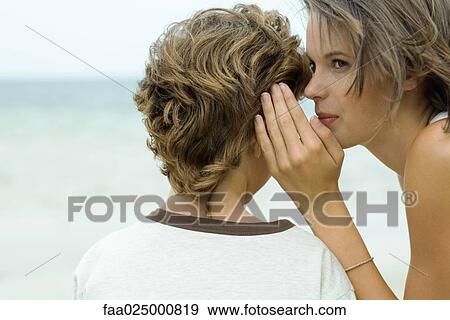 Teenage girl whispering in boy's ear, cropped view View Large Photo Image Stock Photo - Teenage girl whispering in boy's ear, cropped view. Fotosearch
