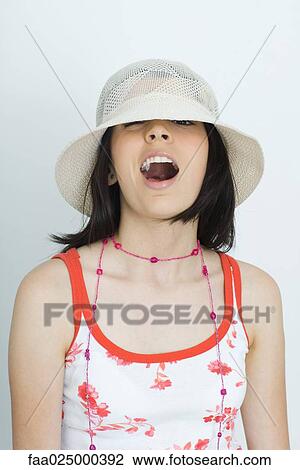 Teenage girl winking at camera from beneath hat, open mouth View Large Photo Image Stock Image - Teenage girl winking at camera from beneath hat, open mouth. Fotosearch