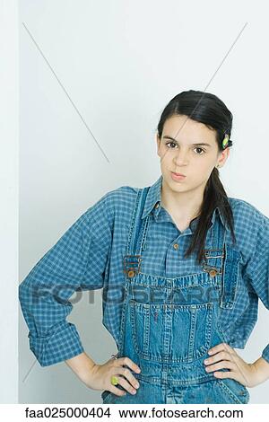 Picture - Teenage girl with hands on hips, smirking at camera. Fotosearch
