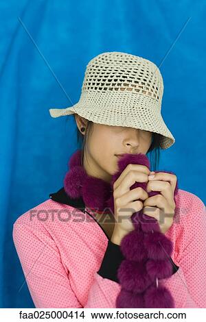 Teenage girl with hat covering eyes, holding boa, portrait View Large Photo Image Picture - Teenage girl with hat covering eyes, holding boa, portrait. Fotosearch