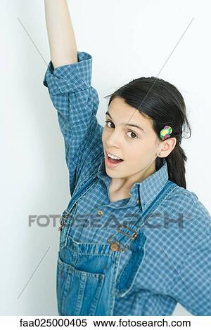 Teenage girl with one arm raised, smiling at camera View Large Photo Image Stock Photography - Teenage girl with one arm raised, smiling at camera. Fotosearch