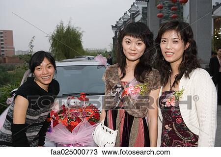 Three female friends standing in front of decorated car, smiling at camera View Large Photo Image Stock Image - Three female friends standing in front of decorated car, smiling at camera. Fotosearch
