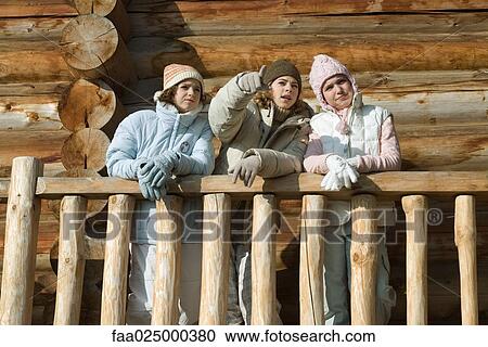 Three preteen or teen girls standing on deck of log cabin, looking away, low angle view View Large Photo Image Stock Image - Three preteen or teen girls standing on deck of log cabin, looking away, low angle view. Fotosearch