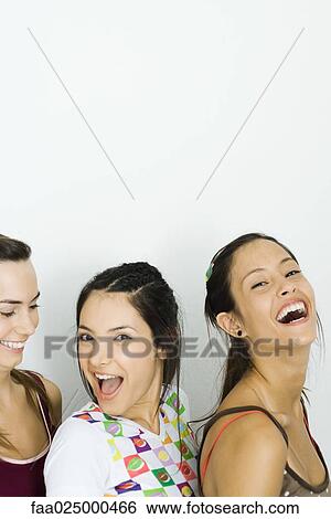 Three young friends smiling together, two looking at camera View Large Photo Image Stock Photograph - Three young friends smiling together, two looking at camera. Fotosearch
