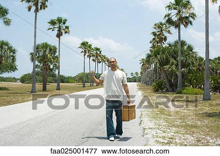 thumb, standing, suitcase, road, hand raised, holding View Large Photo Image Stock Photo - thumb, standing, suitcase, road, hand raised, holding. Fotosearch