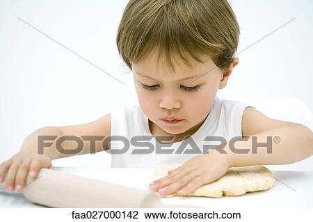 Toddler boy rolling out dough with rolling pin, close-up View Large Photo Image Stock Image - Toddler boy rolling out dough with rolling pin, close-up. Fotosearch