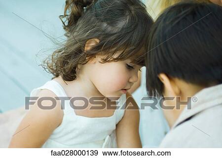 Stock Photo - Two children face to face, looking down, cropped view. Fotosearch